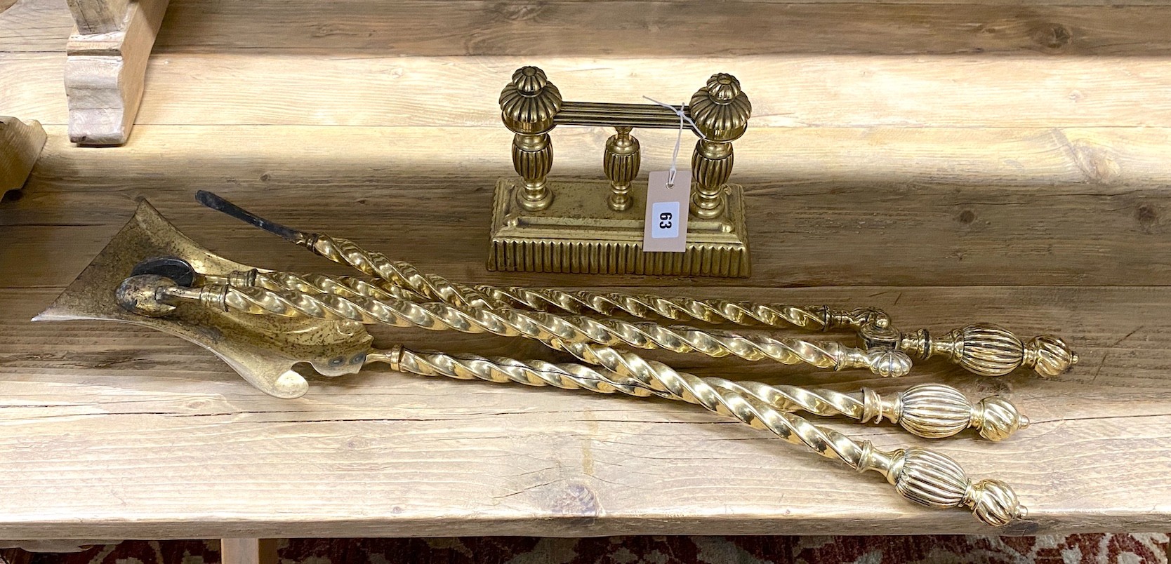 A set of three Edwardian brass fire implements and a fire dog